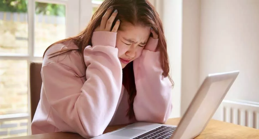 Joven angustiada frente al computador para ilustrar nota sobre qué es cyberbullying y casos