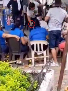 Momento en que una mujer le ofrece una cerveza al alcalde de Cartagena, William Dau