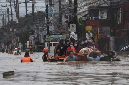 Inundaciones en Filipinas por huracán Vamco, ilustra nota de hombre que camina por cables de alta tensión para conseguir comida