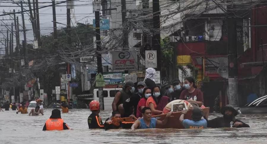 Inundaciones en Filipinas por huracán Vamco, ilustra nota de hombre que camina por cables de alta tensión para conseguir comida