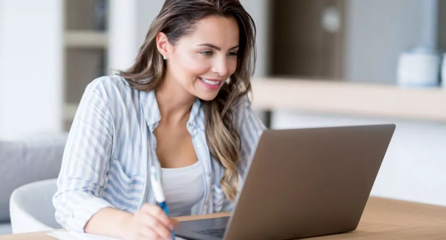 Mujer usando computador para ilustrar nota sobre mejores sitios de Internet para buscar empleo