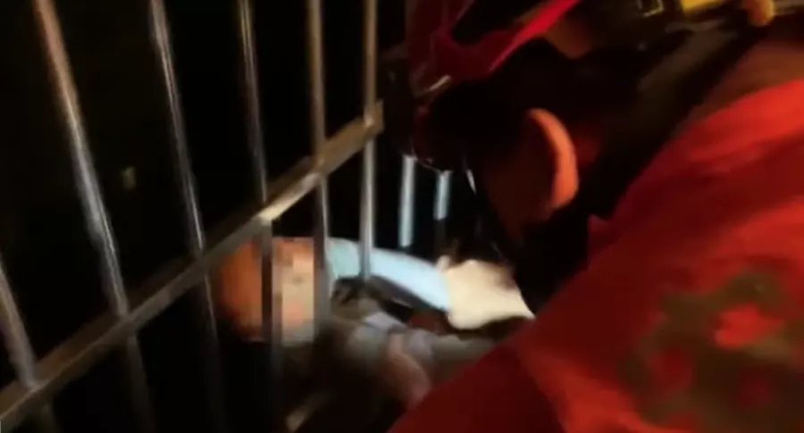 Captura de pantalla del momento en que rescatan a niño de 2 años que quedó atrapado en una reja tras caer desde piso 13