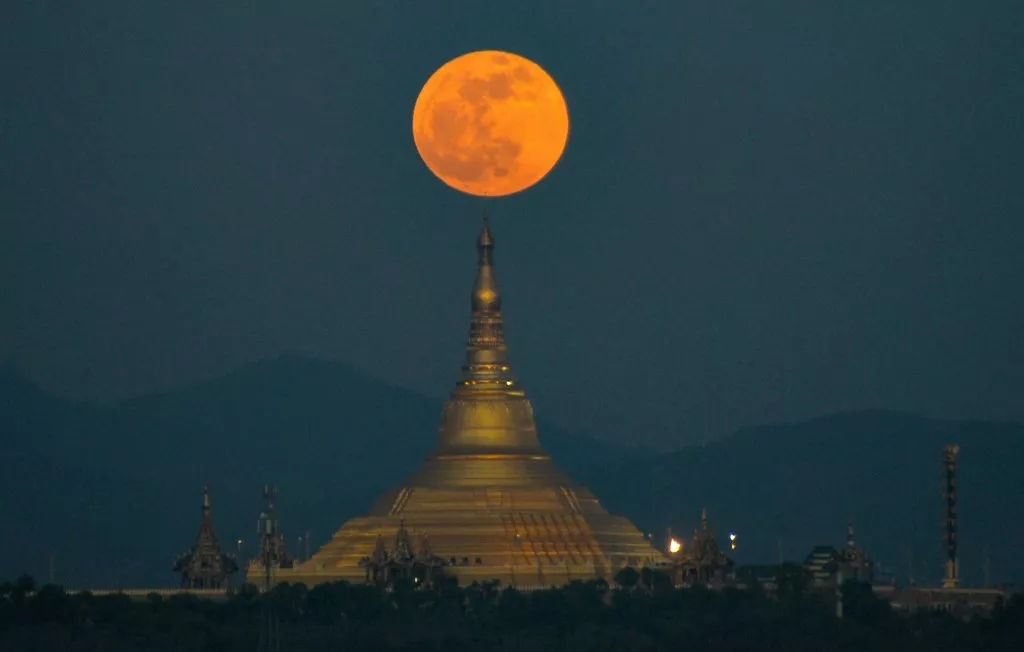 Imagen de la Luna sobre una pagoda en Naypyidaw, Birmania, el 30 de noviembre de 2020 / AFP. 
