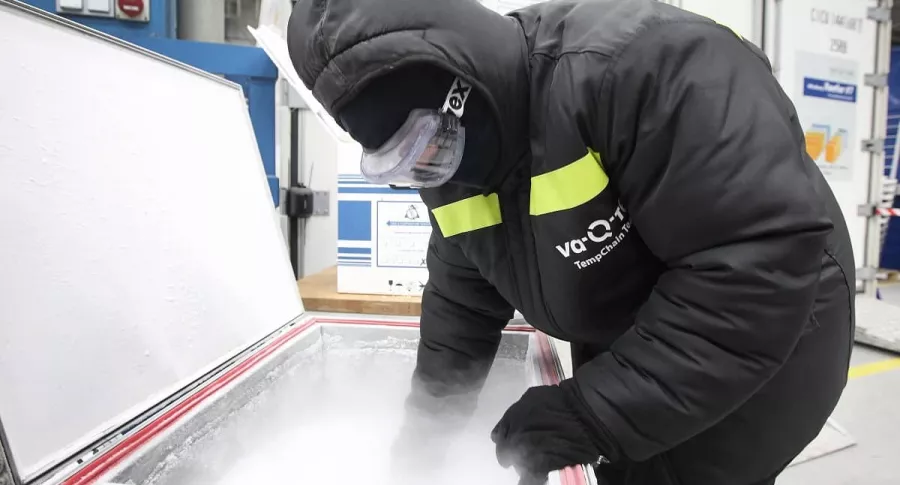Un empleado de la empresa alemana Va-Q-Tec llena hielo seco en un contenedor de refrigeración aislado al vacío, el primero de diciembre de 2020.