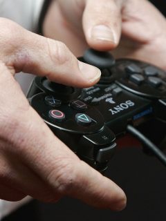 hombre jugando PlayStation (imagen de referencia).