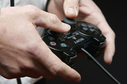 hombre jugando PlayStation (imagen de referencia).