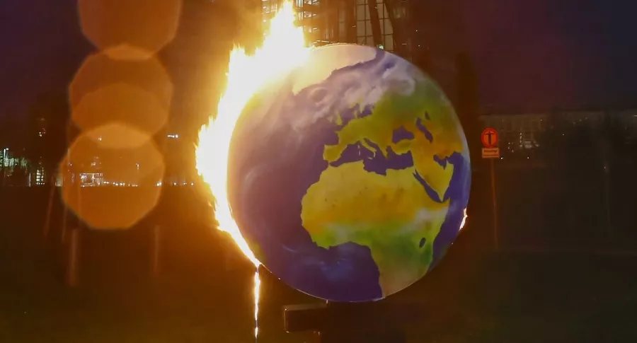 Un mundo en llamas, para alertar sobre el calentamiento global, es usado por activistas del grupo ambientalista Koala Kollektiv, durante una protesta frente a la sede del Banco Central Europeo (BCE) en Frankfurt am Main, Alemania, el 21 de octubre de 2020.
