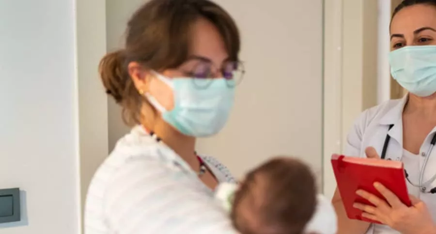 Enfermera carga a bebé, ilustra nota de enfermera que deja caer a bebé recién nacido por mirar celular