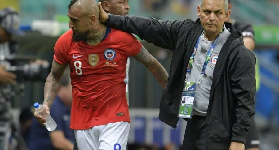Reinaldo Rueda tocando la cabeza de Arturo Vidal durante un partido de la selección de Chile.