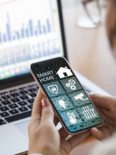 Mujer usando aplicación de hogar inteligente para ilustrar nota sobre 'gadgets' más deseados en las casas
