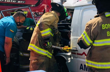 Imagen del momento en que bomberos rescatan a dos personas atrapadas en la ambulancia, que chocó con un bus de Transmilenio en Kennedy