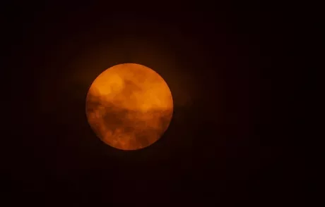 Una luz roja hizo parte del encuentro entre la luna y el sol / AFP.
