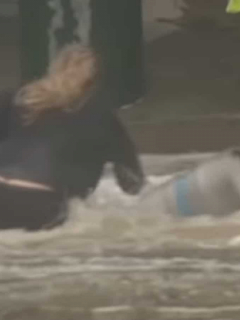 Imagen de la mujer que se lanzó a una inundación para rescatar barriles de cerveza.