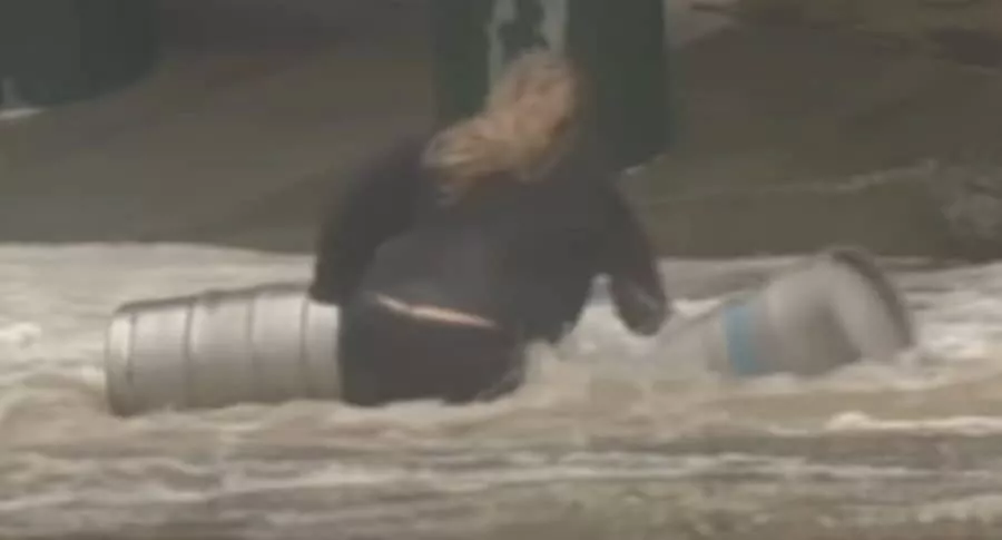 Imagen de la mujer que se lanzó a una inundación para rescatar barriles de cerveza. 