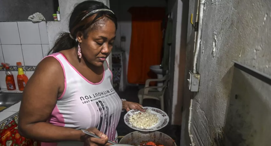 Elizabeth Mosquera, una empleada de servicio doméstico desempleada que perdió su trabajo durante la pandemia del COVID-19, sirve la cena en su casa en Medellín, Colombia, el 7 de diciembre de 2020.