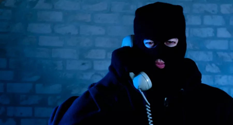 Ladrón con capucha y teléfono en mano, ilustra nota de ladrones que llamaron accidentalmente a la policía
