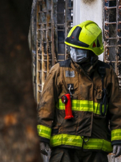 Uno de los bomberos del rescate a las fueras de la casa incendiada.