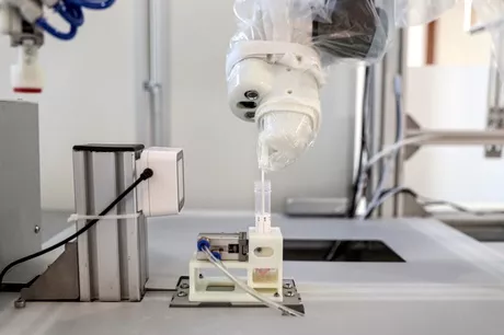 El robot raspa delicadamente la garganta de los pacientes con un hisopo / AFP. 