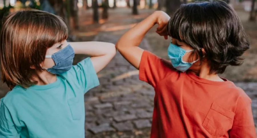 Imagen de niños con tapabocas que ilustra información sobre plan de vacunación que no les da prioridad por tener menor riesgo