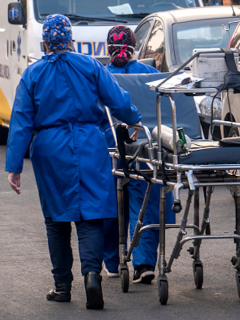 Profesionales de la salud transportan a un paciente de coronavirus.