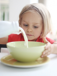 Niña tomando leche, producto que en Colombia está siendo rendido con lactosuero