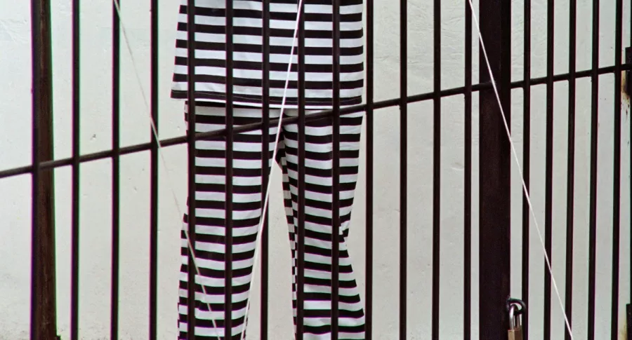 Imagen de hombre con traje de rayas detrás de una rejas ilustra artículo Cadena perpetua para violadores de niños podría caerse por un vicio