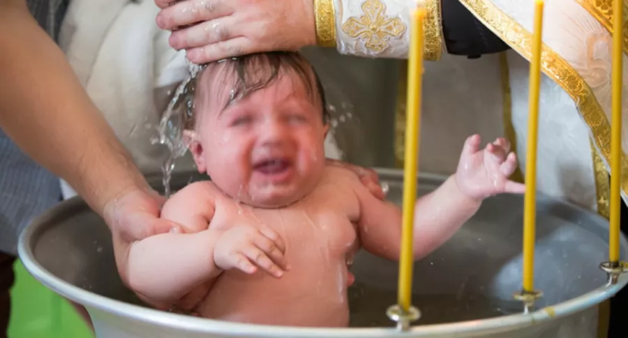 Niño siendo bautizado, ilustra nota de conmoción en Rumania por muerte de bebé durante bautismo