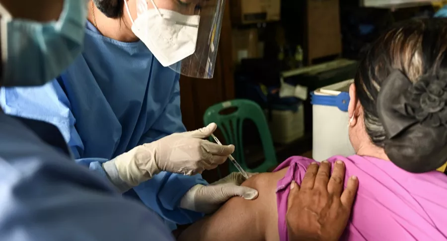 Imagen de vacunación a una mujer ilustra artículo OMS pide más rapidez en vacunación contra coronavirus