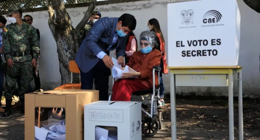 Candidato Andrés Arauz ayuda a su abuela a votar en los comicios presidenciales 2021 de Ecuador.