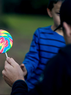 Adulto le ofrece dulces a un niño.