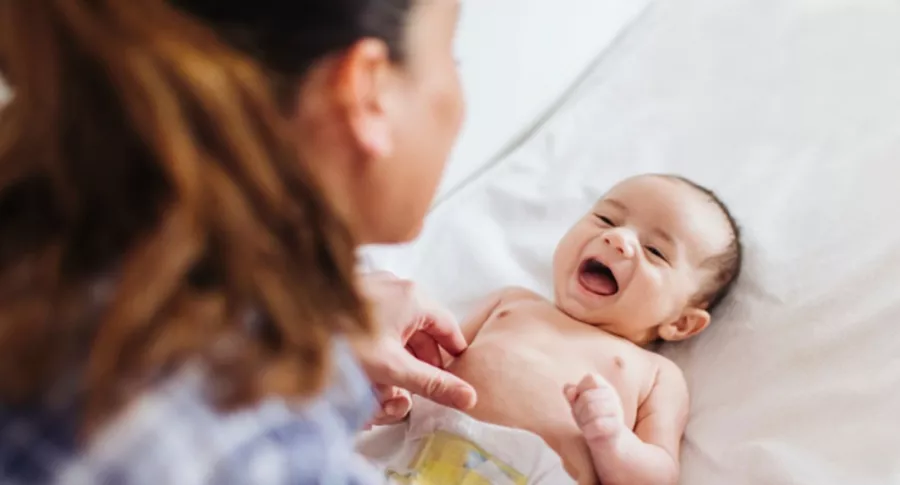 Bebé recién nacido sonriendo con su mamá, ilustra nota de hallazgo de bebé recién nacido con anticuerpos tras vacunación de su mamá