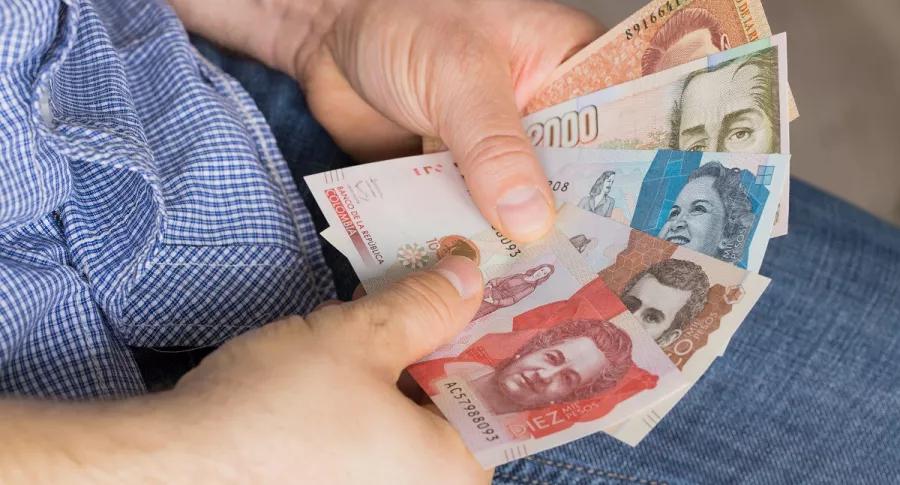 Hombre contando dinero. Imagen ilustrativa del pago del impuesto predial en Bogotá