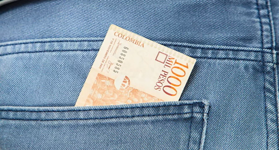 Billete de mil pesos en un bolsillo.