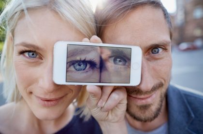 Hombre y mujer con celular en los ojos, ilustra nota de nuevo reto viral de ilusión óptica: ¿Cuántos colores ve?