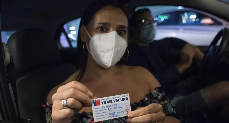 Persona mostrando certificado de vacunación ilustra la nota sobre que el Ministerio de Salud confirmó que Chille llegó este lunes a los dos millones de vacunados contra el coronavirus.