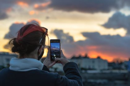 Foto de mujer  con su celular ilustra nota sobre ¿Cuáles son las mejores aplicaciones para editar fotos?