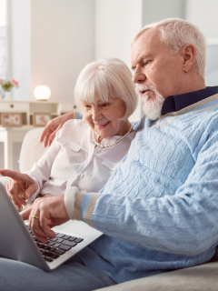 Pareja sentada, buscando algo en internet. Imagen ilustrativa a 'Mi planilla' la herramienta para hacer pagos de la Seguridad Social.