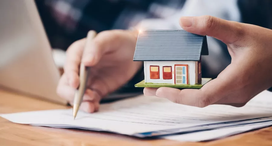 Se están firmando unos documentos, los cuales se entiende que son relacionados con una vivienda. Imagen ilustrativa a loas razones por las que se puede cancelar un contrato de arrendamiento.