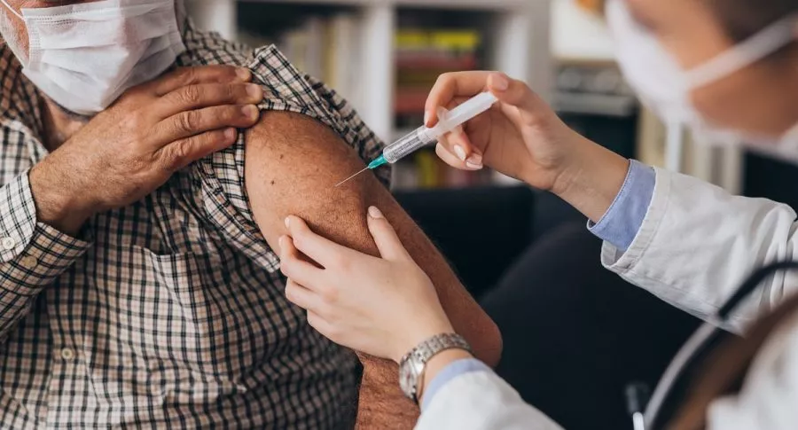 Doctor vacuna a un hombre. Imagen ilustrativa al tiempo de espera de las vacunas para la población que ya tuvo COVID-19 