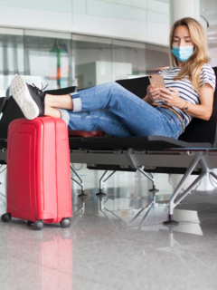 Mujer en aeropuerto con tapabocas, ilustra nota de OMS pide que la vacuna contra el coronavirus no sea requisito para viajar