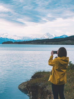 Mujer toma foto con su celular a un lago, ilustra nota de mujer recupera su iPhone funcional meses después de que se le cayó a lago