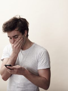 Foto de hombre con el celular ilustra nota sobre iOS 14.4.1