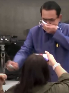 Captura de pantal del video del primer ministro tailandés Chan-ocha rocía desinfectante a periodistas
