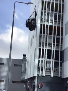 Captura de pantalla de foto de Porsche que atraviesa pared de parqueadero y queda colgado en el aire, en Moscú