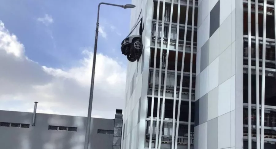 Captura de pantalla de foto de Porsche que atraviesa pared de parqueadero y queda colgado en el aire, en Moscú