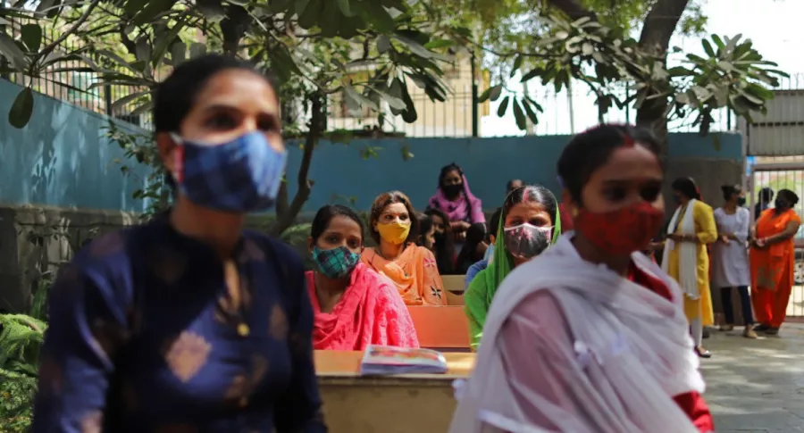 Mujeres con tapabocas en la India, ilustran nota de Encuentran en India una "variante doble mutante" del coronavirus