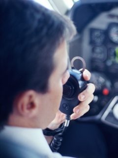 Piloto de avión habla por micrófono, ilustra nota de graban a piloto insultando a ciudad en la que acaba de aterrizar, en EEUU