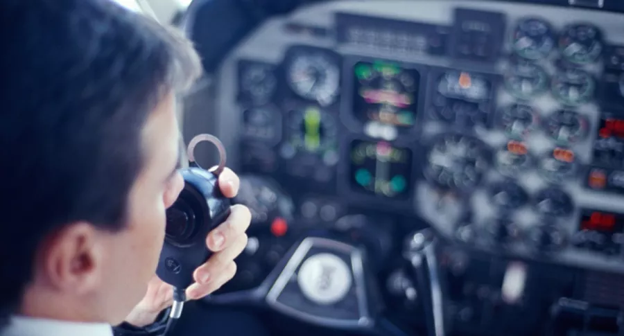 Piloto de avión habla por micrófono, ilustra nota de graban a piloto insultando a ciudad en la que acaba de aterrizar, en EEUU