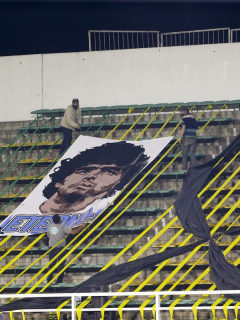 Imagen de diego maradona en tribuna de estadio ilustra artículo Diego Maradona murió solo y abandonado, dice su abogado y apoderado