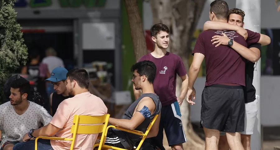 Jóvenes se reúnen en una calle de la ciudad costera israelí de Tel Aviv, este domingo, después de que las autoridades anunciaran que ya no se necesitaban máscaras faciales para la prevención del COVID-19 en el exterior.